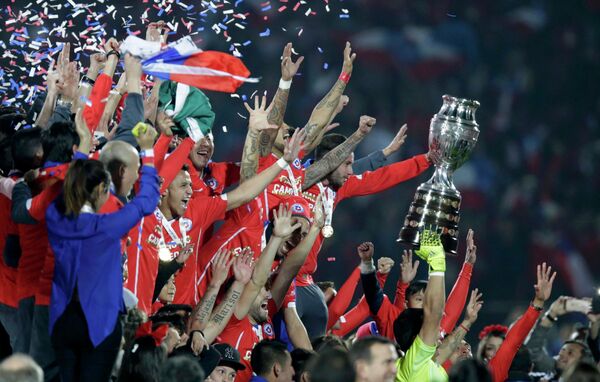 Футболисты сборной Чили с трофеем за победу на Кубке Америки