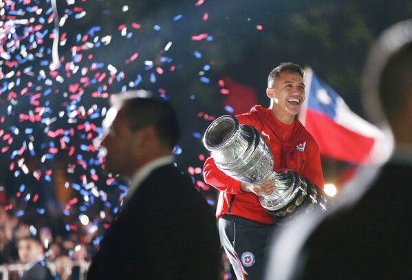 Нападающий сборной Чили Алексис Санчес с трофеем за победу на Кубке Америки