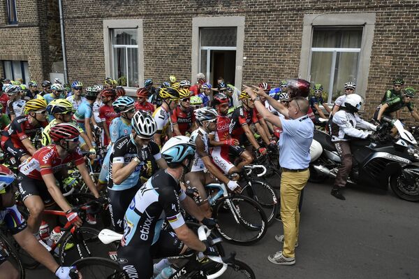 Велосипедисты ждут возобновления гонки после завала во время третьего этапа Тур де Франс-2015