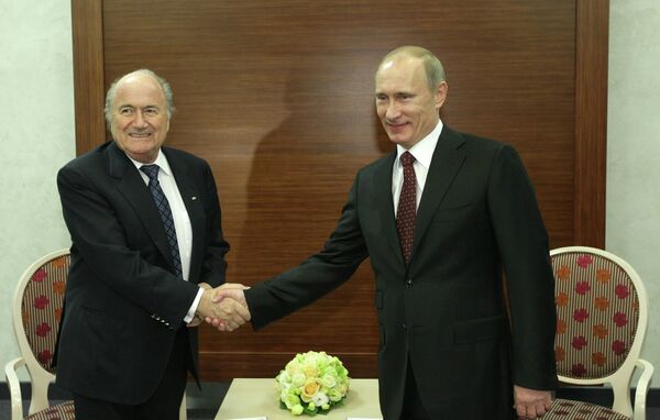 Президент РФ Владимир Путин (справа) беседует с президентом ФИФА Йозефом Блаттером (слева)
