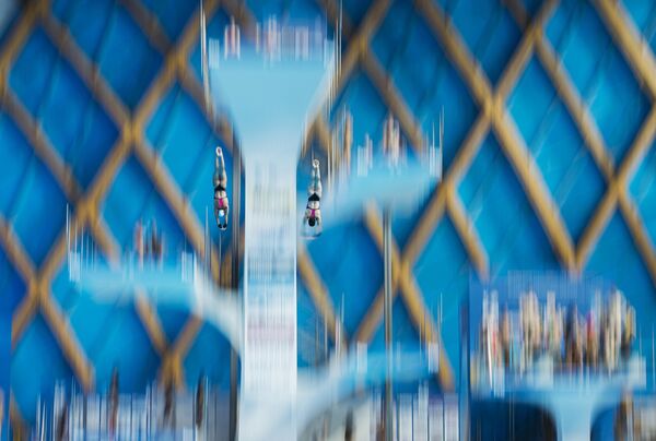 Спортсмены разминаются перед предварительным раундом соревнований по синхронным прыжкам в воду с вышки 10 м среди женщин