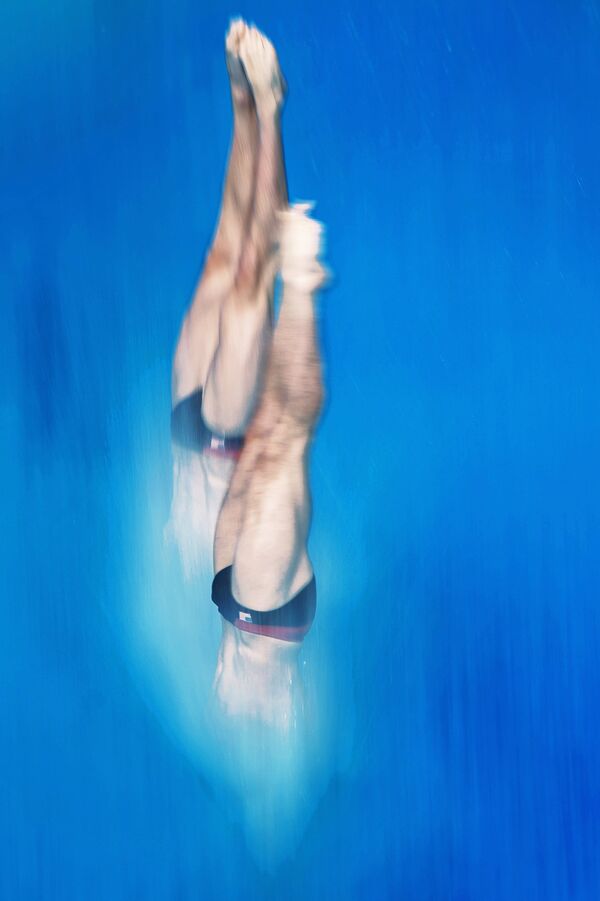 Спортсмены на разминке перед соревнованиями по синхронным прыжкам в воду с вышки 10 м среди мужчин