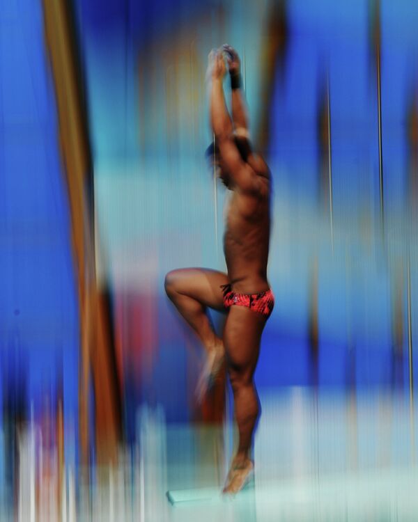 Участник во время разминки перед соревнованиями по прыжкам в воду с трамплина 1 м среди мужчин