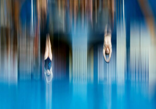 Спортсмены на разминке перед соревнованиями по синхронным прыжкам в воду с трамплина 3 м
