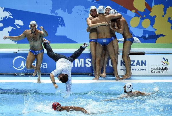 Игроки сборной Греции и главный тренер команды Теодорос Влахос радуются победе в матче против команды Италии за 3-е место по водному поло среди мужчин