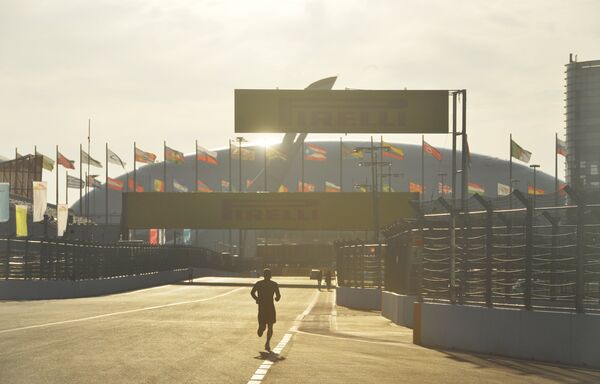 Мужчина совершает пробежку по трассе Гран-при России в Олимпийском парке Сочи