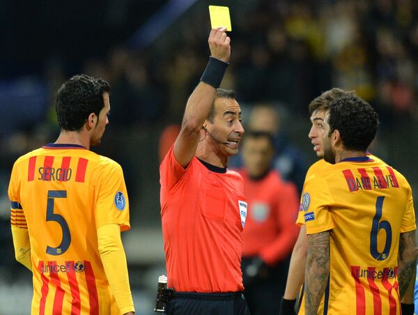 Главный судья матча Мануэл Жорже Соуза (в центре) показывает жёлтую карточку защитнику Барселоны Дани Алвесу (справа)