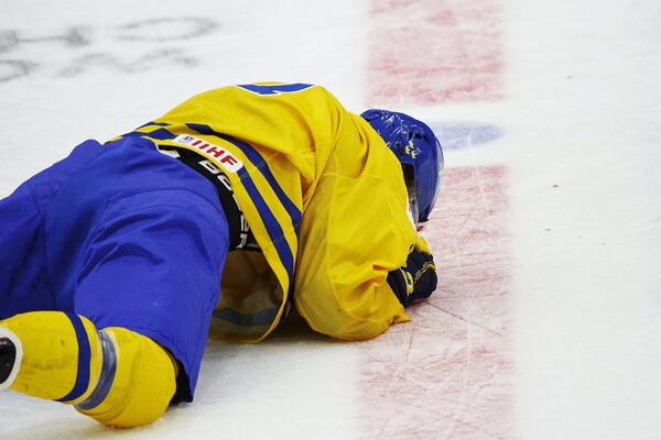 Шведский хоккеист Уильям Нюландер после столкновения со швейцарцем Крисом Эгли