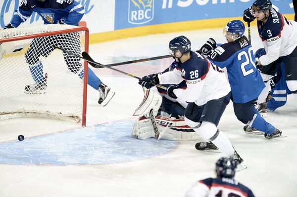 Нападающий молодежной сборной Финляндии по хоккею Себастьян Ахо (второй справа) забрасывает шайбу в ворота сборной Словакии в матче МЧМ