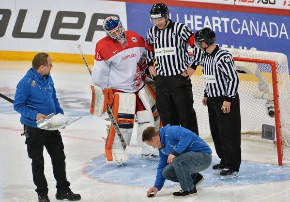 Работники Хартвалл-Арены поправляют лед перед воротами сборной Дании