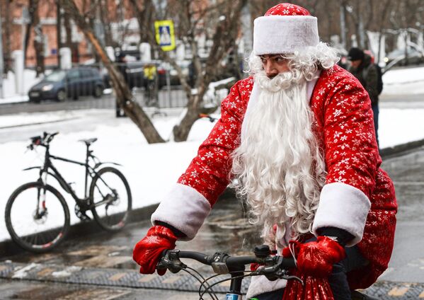 Участник первого зимнего Московского велопарада в костюме Деда Мороза перед стартом велопробега