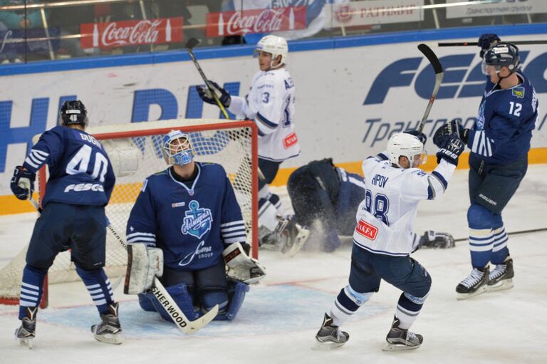Нападающий ХК Динамо Илья Шипов (второй справа) радуется заброшенной шайбе в ворота голкипера Адмирала Игоря Бобкова (второй слева)