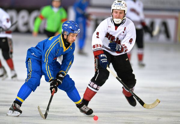 Игрок сборной Швеции по хоккею с мячом Ханс Андерссон (слева) и игрок сборной Латвии Мартиньш Кречетниковс