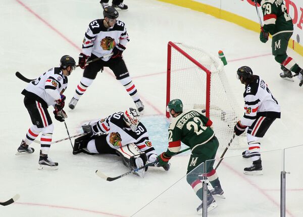 Форвард Миннесоты Нино Нидеррайтер (третий справа) забрасывает шайбу в ворота Чикаго в матче НХЛ на открытом воздухе