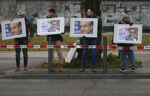 Люди с плакатами поддерживают шейха Салмана у штаб-квартиры ФИФА
