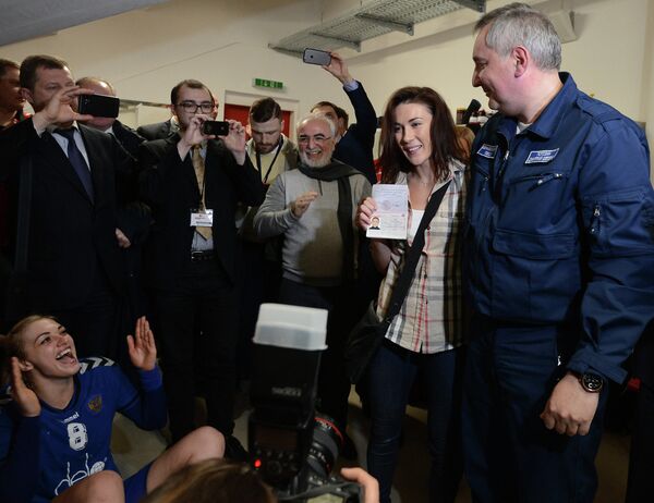 Дмитрий Рогозин (справа) во время вручения паспорта гражданина РФ украинской гандболистке Юлии Манагаровой