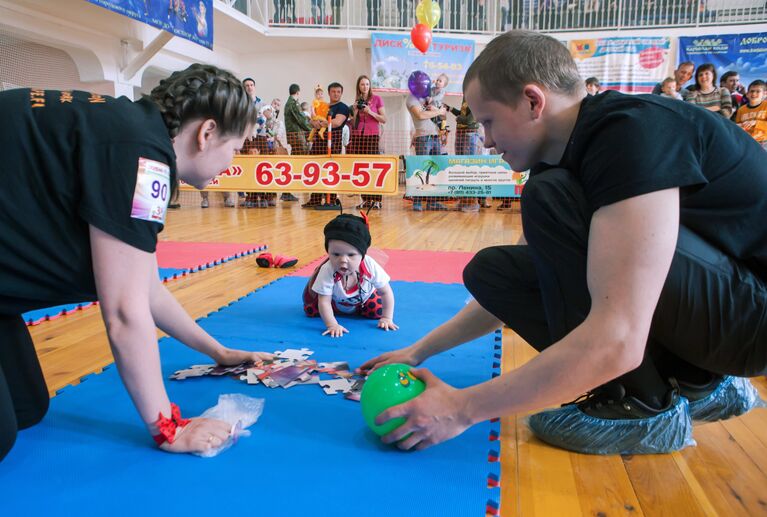 Родители с ребенком участвуют в III марафоне ползунков Маленький Чемпион