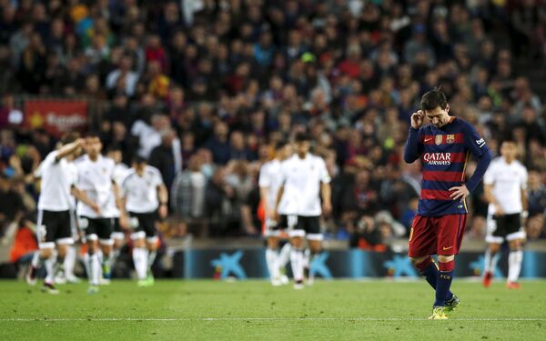 Форвард Барселоны Лионель Месси на фоне радующихся футболистов Валенсии