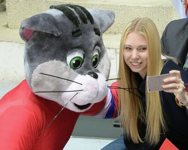 Болельщица сборной России фотографируется с талисманом команды