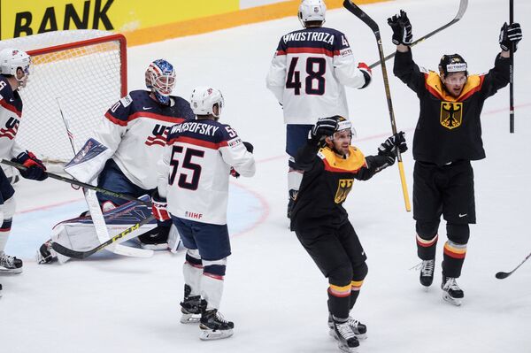 Хоккеисты сборной Германии (справа) радуются забитой шайбе американцам