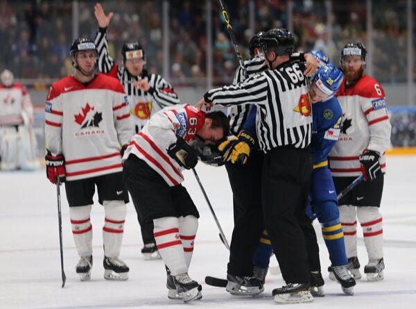 Потасовка между форвардом сборной Канады Брэдом Маршаном (в центре) и нападающим шведской сборной Юханом Сундстрёмом (справа)