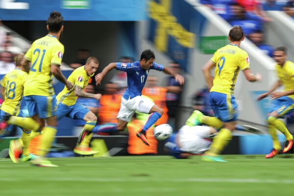 Нападающий сборной Италии Эдер Мартинс ( в центре) забивает мяч