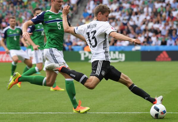 Нападающий сборной Германии Томас Мюллер и защитник сборной Северной Ирландии Джонни Эванс (справа налево)