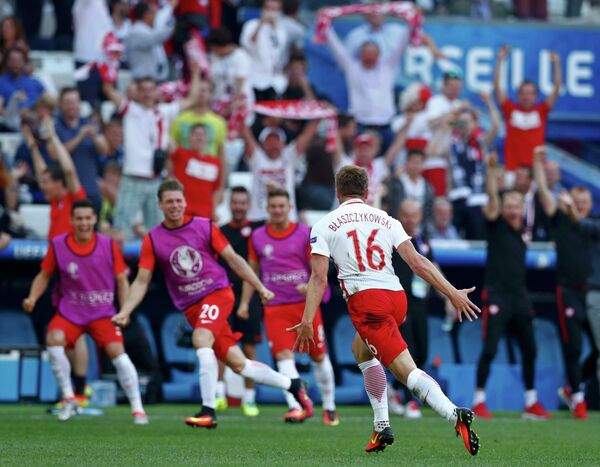 Футболисты сборной Польши радуются забитому мячу в исполнении Якуба Блащиковского (на переднем плане)