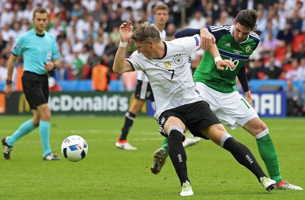 Нападающий сборной Северной Ирландии Кайл Лафферти и полузащитник сборной Германии Бастиан Швайнштайгер (справа налево)
