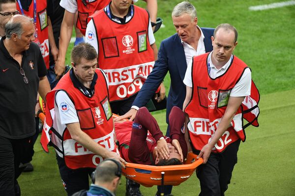 Медики выносят на носилках с поля нападающего сборной Португалии Криштиану Роналду (в центре на переднем плане)