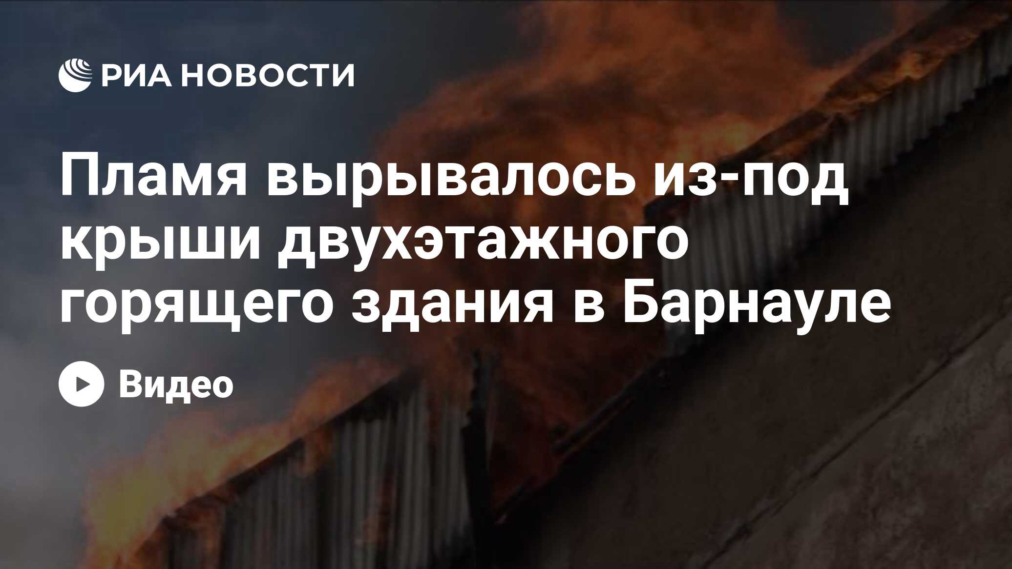 Пламя вырывалось из-под крыши двухэтажного горящего здания в Барнауле